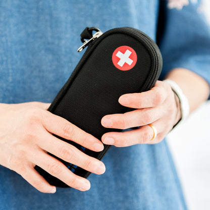 Slim black medicine case with wrist strap, zipper closure, and red medical cross symbol – designed to carry epinephrine, inhalers, or emergency medications securely for everyday or travel use.
